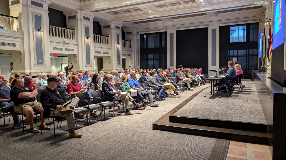 Audience of elected officials looking at a panel for a World Cup briefing