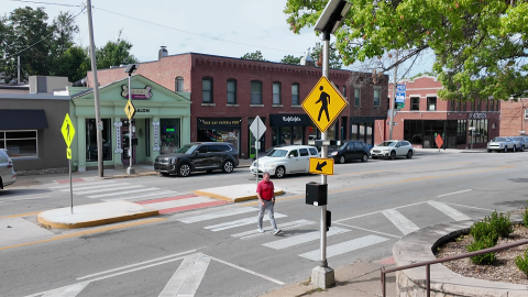 Man walks across crosswalk to test compliance of drivers for pedestrian safety on Westport Rd and Genesee Street